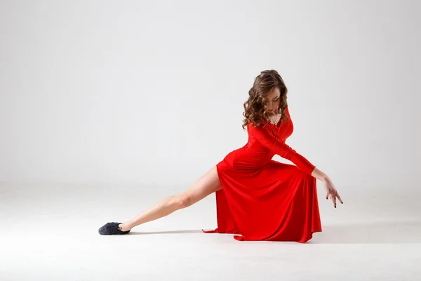 Dancing lady in a red dress. Contemporary modern dance on a white background isolated. Fitness, stretching model — Zdjęcie stockowe
