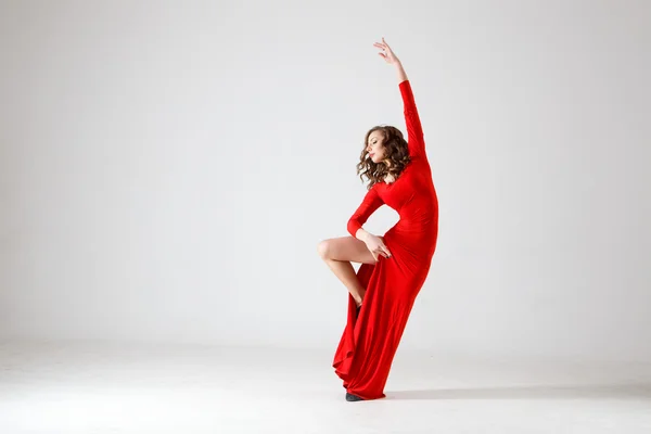 Signora danzante con un vestito rosso. Danza moderna contemporanea su sfondo bianco isolato. Fitness, modello di stretching — Foto Stock