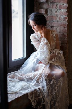 Gelin sabahı çatı katında. Bir sabah beyaz bir negligee güzel esmer genç kadın