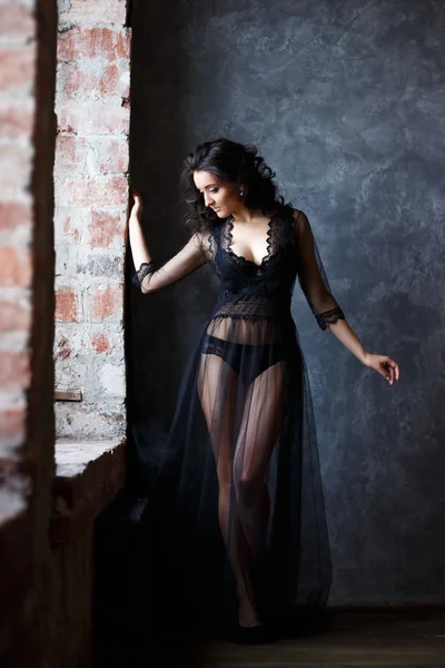 Portrait of gorgeous young brunette woman in a transparent black dress — Stock Photo, Image