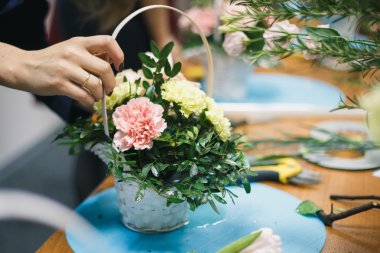 Çiçek atölye - çiçekçi bir buket bir sepet içinde yapar. Öğrenciler çiçekçi birlikte çalışma.