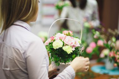 Çiçek atölye - çiçekçi bir buket bir sepet içinde yapar. Öğrenciler çiçekçi birlikte çalışma.