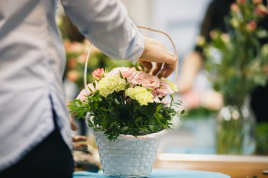Çiçek atölye - çiçekçi bir buket bir sepet içinde yapar. Öğrenciler çiçekçi birlikte çalışma.