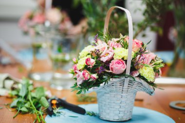 Çiçekçi işyeri: çiçek ve aksesuarları bir arka plan üzerinde bir sepet içinde güzel buket. yumuşak odak