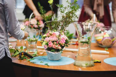 Çiçek atölye - çiçekçi bir buket bir sepet içinde yapar. Öğrenciler çiçekçi birlikte çalışma.