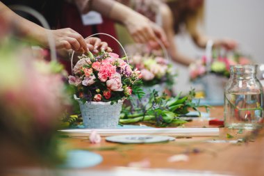 Çiçek atölye - çiçekçi bir buket bir sepet içinde yapar. Öğrenciler çiçekçi birlikte çalışma.