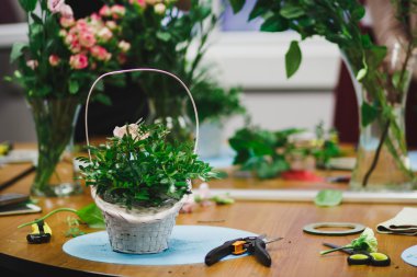 Çiçekçi işyeri: çiçek ve aksesuarları. güzel buket çiçek ve aksesuar arka plan üzerinde bir sepet içinde. yumuşak odak