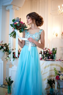 Bir lüks mavi güzel genç bayan elbise bir buket çiçek ile zarif iç