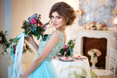 Bir lüks mavi güzel genç bayan elbise bir buket çiçek ile zarif iç