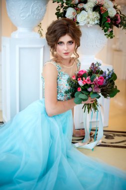 Bir lüks mavi güzel genç bayan elbise bir buket çiçek ile zarif iç