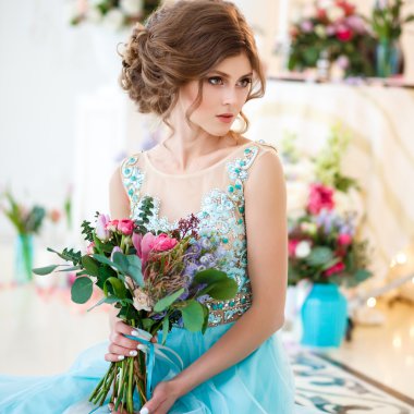 Bir lüks mavi güzel genç bayan elbise bir buket çiçek ile zarif iç