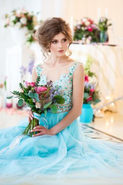 Bir lüks mavi güzel genç bayan elbise bir buket çiçek ile zarif iç