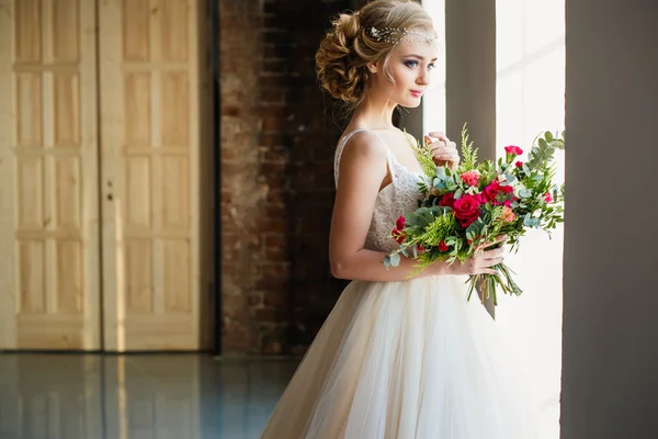 Beautiful bride in gorgeous luxury dress holding bouquet in a loft space. Modern wedding photo — Stock Photo, Image