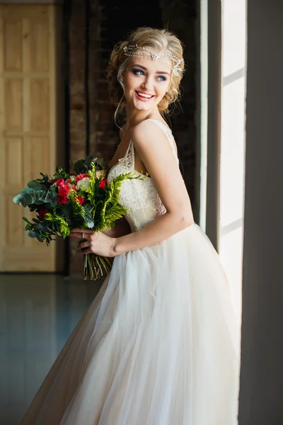 Vacker brud i vackra lyx klänning innehav bukett i ett loft utrymme. Modern bröllopsfoto — Stockfoto