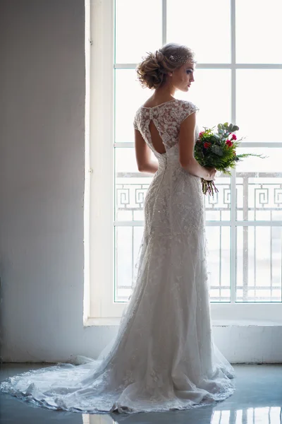 Bela noiva em lindo vestido de luxo segurando buquê em um espaço loft. Moderna foto do casamento — Fotografia de Stock