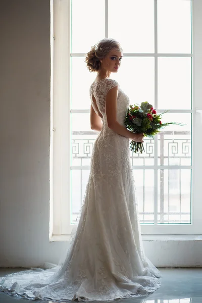 로프트 공간에서 꽃다발을 들고 화려한 고급 드레스에 아름다운 신부. 현대 웨딩 사진 — 스톡 사진