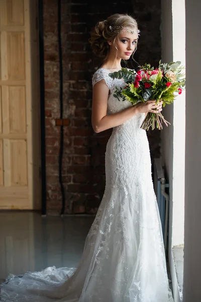 Beautiful bride in gorgeous luxury dress holding bouquet in a loft space. Modern wedding photo — Stock Photo, Image