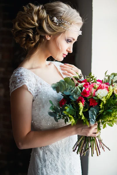 로프트 공간에서 꽃다발을 들고 화려한 고급 드레스에 아름다운 신부. 현대 웨딩 사진 — 스톡 사진
