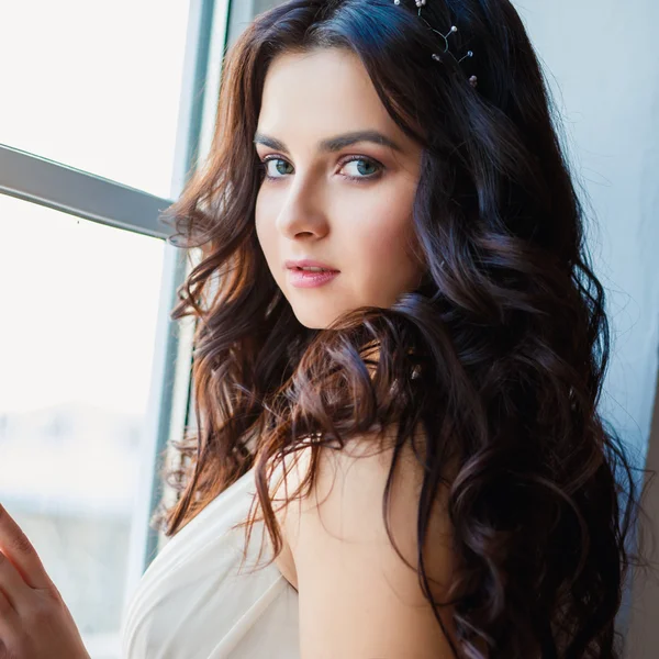 Pretty brunette young woman in gorgeous evening dress in a loft space in a morning. Close-up beauty portrait — Stock Photo, Image