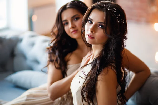 Belle gemelle giovani donne in abiti da sera splendidi in uno spazio soppalco in una mattina — Foto Stock