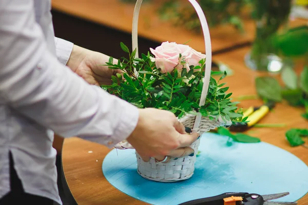 Taller floral - florista hace un ramo en una canasta. Estudiantes floristas trabajan juntos . — Foto de Stock