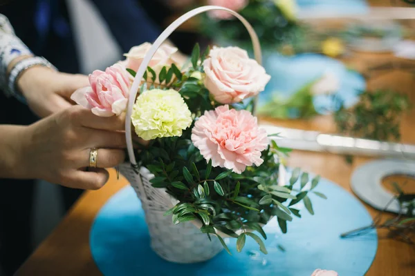 Квіткова майстерня - флорист робить букет у кошику. Студенти флористи працюють разом . — стокове фото
