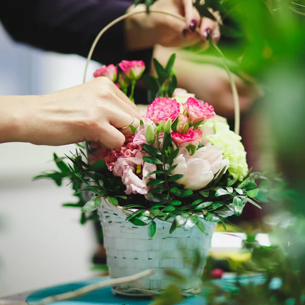 Квіткова майстерня - флорист робить букет у кошику. Студенти флористи працюють разом . — стокове фото