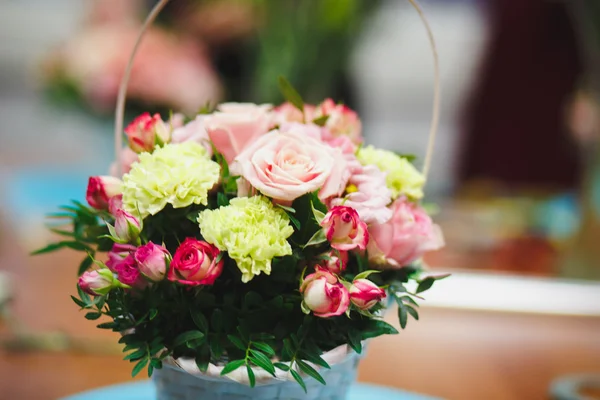 Local de trabalho de florista: buquê bonito em uma cesta em um fundo de flores e acessórios. foco suave — Fotografia de Stock