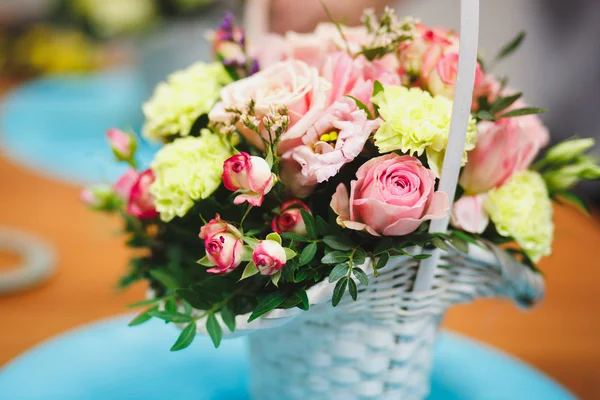 Local de trabalho de florista: buquê bonito em uma cesta em um fundo de flores e acessórios. foco suave — Fotografia de Stock