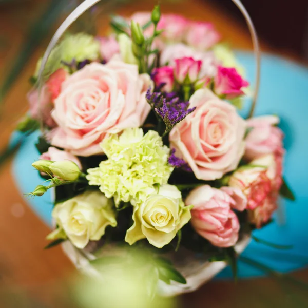 Ανθοπωλεία χώρο εργασίας: όμορφο μπουκέτο σε ένα καλάθι σε φόντο λουλούδια και αξεσουάρ. μαλακή εστίαση — Φωτογραφία Αρχείου