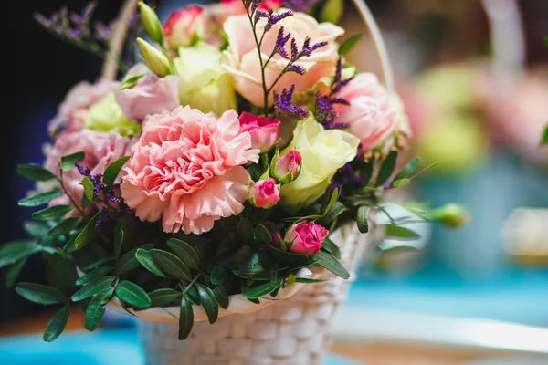 Local de trabalho de florista: buquê bonito em uma cesta em um fundo de flores e acessórios. foco suave — Fotografia de Stock