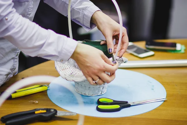 Taller floral - florista hace un ramo en una canasta. Estudiantes floristas trabajan juntos . — Foto de Stock