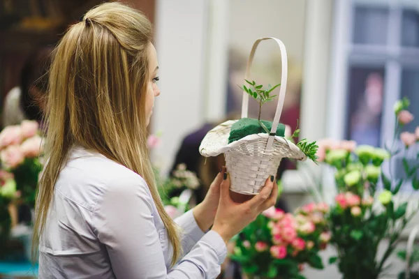 Floral workshop - florist makes a bouquet in a basket. Students florists work together.