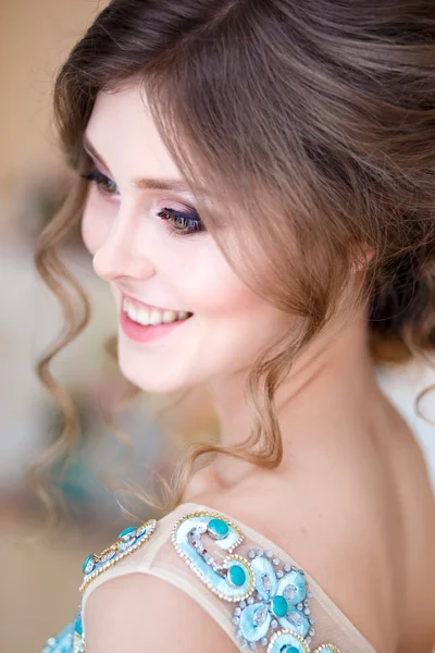 Close-up portrait of beautiful young lady in a luxury blue dress with perfect makeup and hair style — Stock Photo, Image