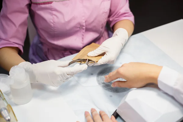 Procedimiento de cuidado de la manicura, foto de cerca de la mano esteticista limado uñas de la mujer en el salón — Foto de Stock