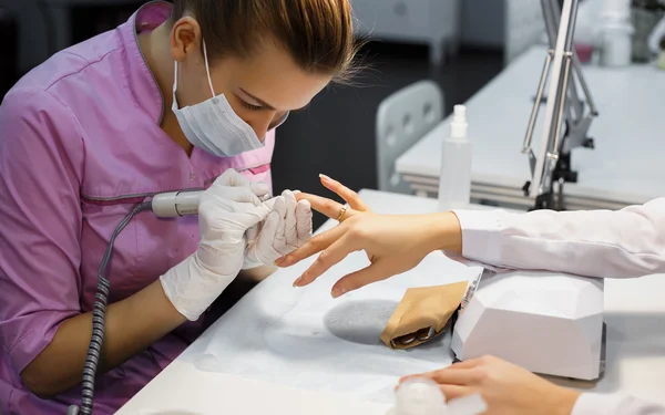 Procedimento de cuidados de manicure, foto de close-up de esteticista mão arquivando unhas de mulher no salão — Fotografia de Stock