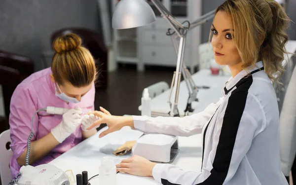 Procedimiento de cuidado de la manicura, foto de cerca de la mano esteticista limado uñas de la mujer en el salón — Foto de Stock