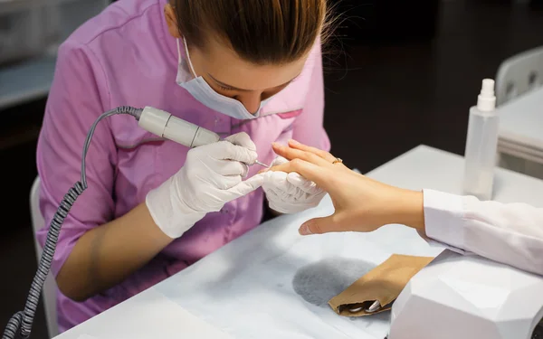 Процедура ухода за маникюром, крупным планом фото женских ногтей в салоне красоты — стоковое фото