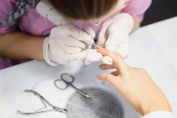 Procedimiento de cuidado de la manicura, foto de cerca de la mano esteticista limado uñas de la mujer en el salón — Foto de Stock