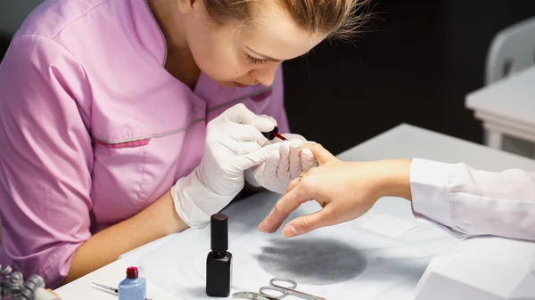 Procedimiento de cuidado de la manicura, foto de cerca de la mano esteticista limado uñas de la mujer en el salón — Foto de Stock