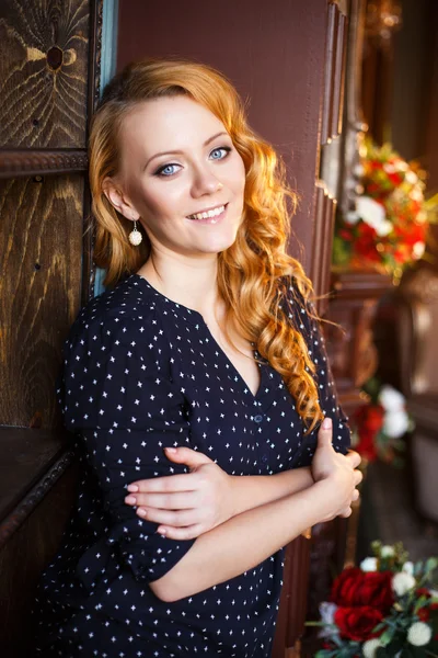 Jonge vrouw met rood haar in een casual kleding in een interieur van de bibliotheek — Stockfoto