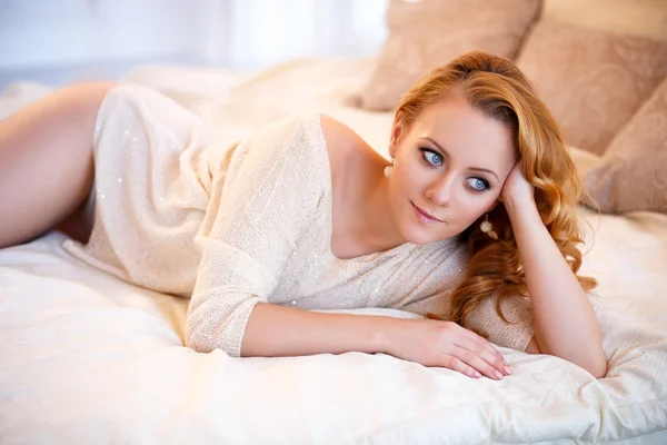 Giovane bella donna in un pullover caldo in una camera da letto leggera in una mattina. Ritratto ravvicinato, occhi azzurri e trucco naturale — Foto Stock