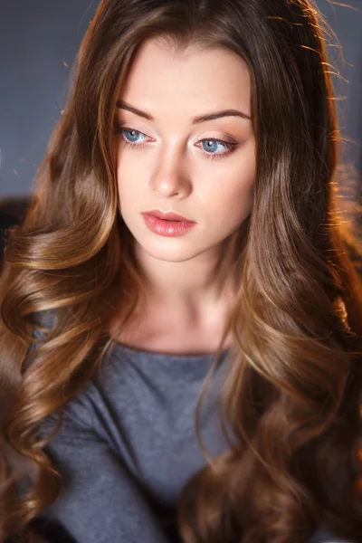 Emotional portrait of a young sensual woman with long curly hair and natural makeup — Stock Photo, Image