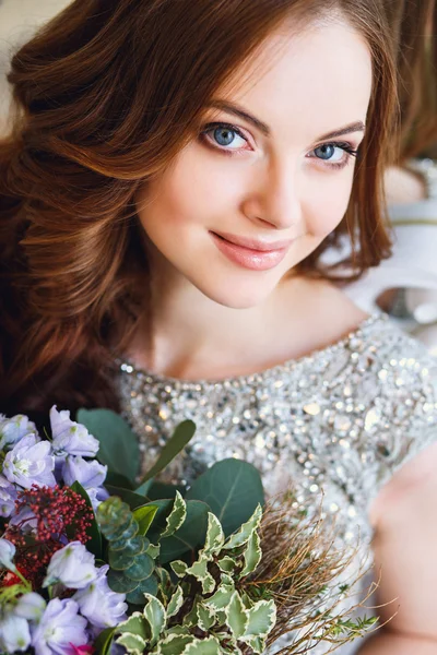 Belle jeune femme dans une robe de luxe à l'intérieur élégant avec un bouquet de fleurs — Photo