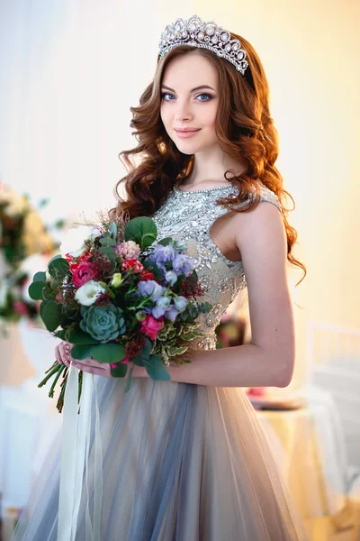 Menina bonita em um vestido de luxo em interior elegante com um buquê de flores — Fotografia de Stock