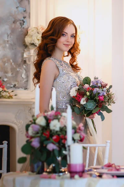 Menina bonita em um vestido de luxo em interior elegante com um buquê de flores — Fotografia de Stock