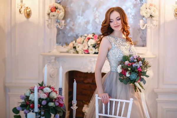 Bella signorina in un abito di lusso in interni eleganti con un mazzo di fiori — Foto Stock