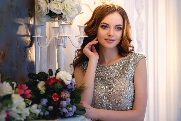 꽃의 꽃다발우아한 인테리어에 고급 드레스에 아름다운 젊은 아가씨 — 스톡 사진