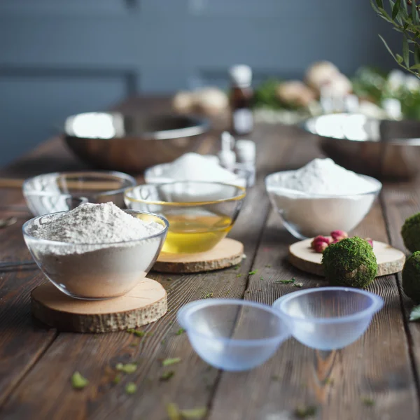 Preparation of bath bombs. Ingredients and floral decor on a wooden vintage table.