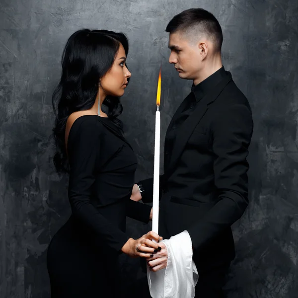 Trollkarl ung man och hans assistent kvinna i en svart kläder hålla ett magiska ljus — Stockfoto